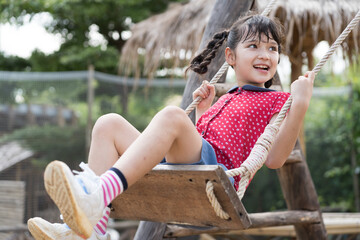 Children, Child girl. Female child girl playing on swing at playground