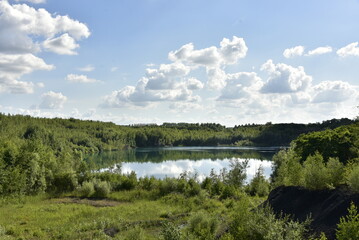 L'une des anciennes carrières remplie d'eau sous des cumulus de beau temps à Écaussinnes-d'Enghien 