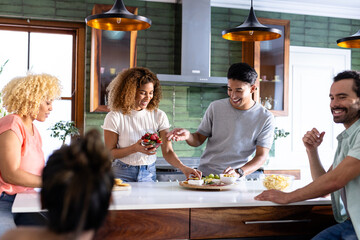 Young friends preparing snacks and enjoying conversation in modern kitchen