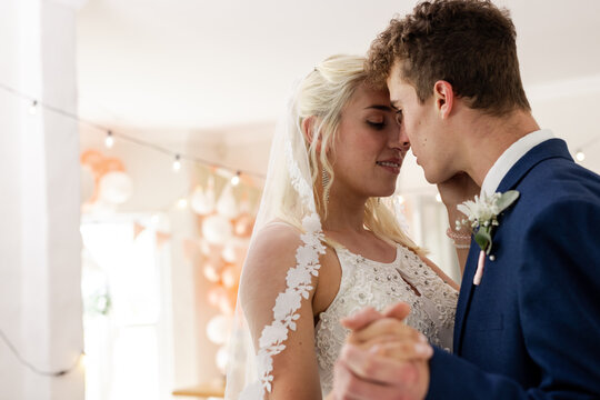 Bride and groom sharing intimate dance, celebrating love at wedding reception