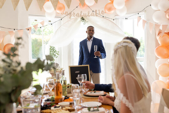 Groom giving heartfelt toast at elegant wedding reception with friends and family
