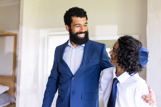 Diverse family, father and son in formal attire, embracing during religious celebration, at home