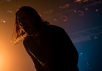 Singer Performing at Concert with Orange Lighting