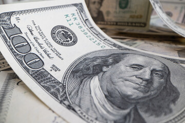 pile of US 100 dollar banknotes on spread dollar banknotes