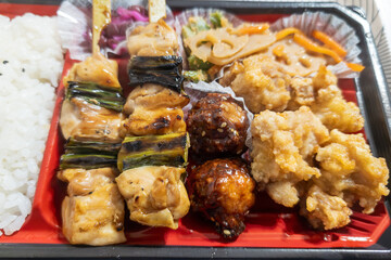 彩り豊かな焼き鳥と唐揚げの弁当
