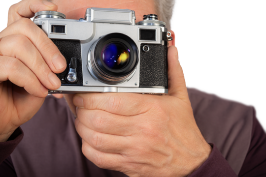 Man holding a vintage camera and preparing to take a photograph, showcasing a passion for photography and nostalgia