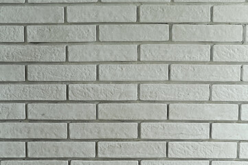 White brick wall with subtle texture creates clean abstract background. Wall shows minimal pattern, light shadows, and neutral color ideal for design themes.
