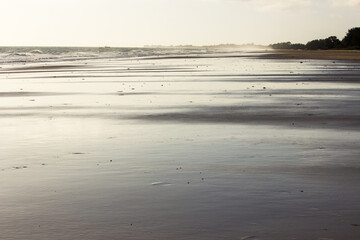 Late afternoon light reflecting silver of the wet sand of the Beach at Inhassoro on the Mozambique coast.
