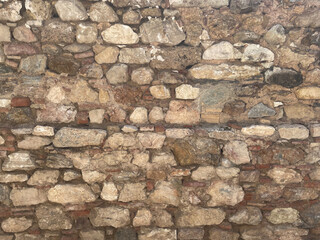 Old brick wall with rough layers of plaster, close-up. Texture for grunge background. Plaster with...