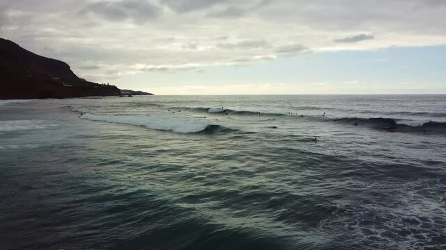 Drone view of surfer riding waves at sunset near Almaciga beach, Tenerife