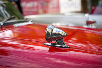 Red classic car with bullet-style chrome mirror. Red vintage sports car with a chrome bullet mirror...