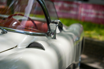 Cream-colored classic convertible with chrome details. Elegant cream convertible with round mirror...