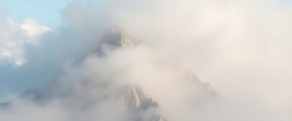Obraz premium very tall mountain surrounded by clouds in the sky