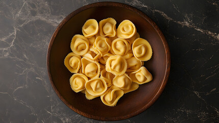 A unique overhead shot of tortellini placed in a circular arrangement, with attention to the details of their texture and the glossy finish of the surface.