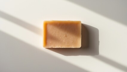 Overhead view of organic hard soap block in natural setting on white background