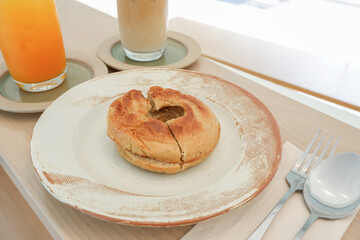 Homemade freshly baked bagels and glass of iced coffee latte and orange juice,ready to eat,sesame and plain bagel served with cream cheese,brunch time.