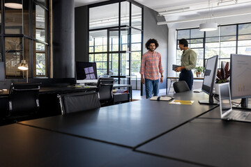 In office with large windows, professionals discussing project in natural light