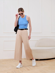 Fototapeta premium A girl in stylish clothes poses in a studio.