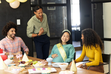 Celebrating at office, diverse colleagues enjoying baby shower with laughter and joy