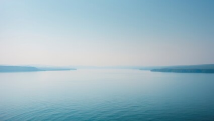 Scenic landscape showcasing a big lake with reflections, hills, and alpine peaks in the background