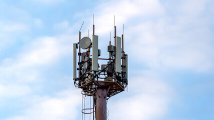 Cell tower against blue sky background