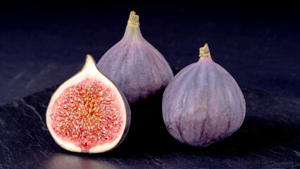 Fototapeta premium Fresh cheese and figs on a black table