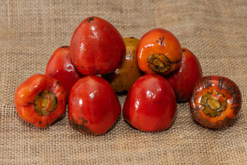 ,Chontaduro fruit (Bactris gasipaes) on a rustic burlap surface. It belongs to the Arecaceae (palm)...