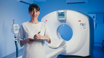 Charming Caucasian woman in medical clothing smiling and holding clipboard with pen in hand....