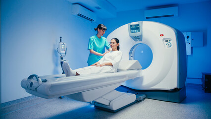 Positive female healthcare worker gently touching patient's shoulder while preparing for scan....