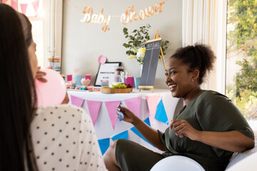 Laughing at baby shower, African American woman amidst festive decorations and games