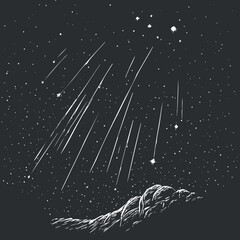 Silhouette of a hill under a night sky filled with stars and multiple shooting meteors streaking down © vadymstock