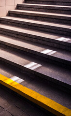 Granite stairs with yellow and white stripes leading upwards