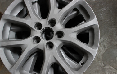 The Primer Layer on a Wheel Rim is Drying on the Garage Floor. Gray custom wheel disc for sport car...