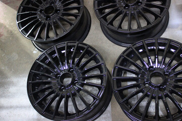 Set of Black Painted Wheel Rims on the Floor at Car Styling Workshop. Black Alloy Wheels for External Car Tuning 