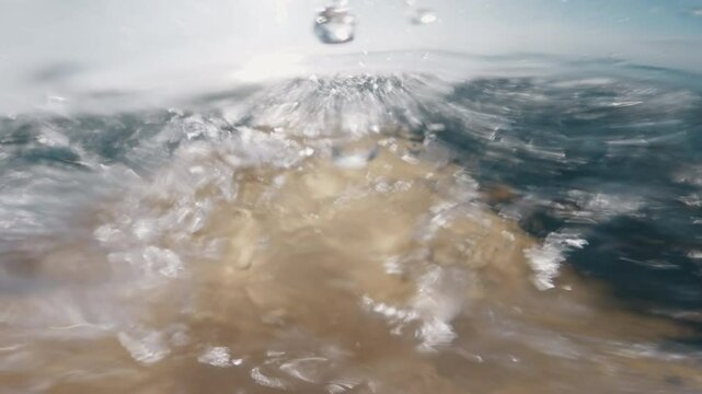 Surfer first person view rowing on surfboard in ocean with breaking waves.
