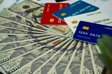 image showing a spread of hundred-dollar bills beneath multiple colorful credit cards. This visually engaging photo represents modern financial concepts