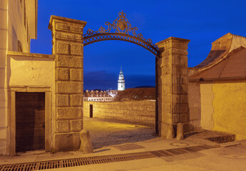 Illuminated tower seen through an ornate stone gate in the old town of Cesky Krumlov, Czech...