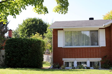 The house estate in the village is surrounded by green trees and bushes.