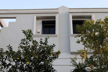 The house estate in the village is surrounded by green trees and bushes.