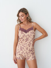 Naklejka premium Fashion model showcasing a floral loungewear set in a stylish indoor setting