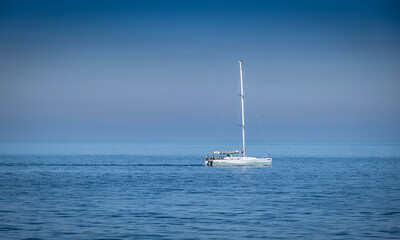 open sea. a white sailboat is sailing.