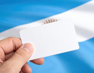 Blank card held by hand in front of argentine flag background