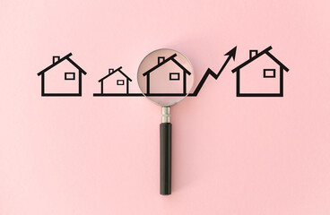A magnifying glass is used to look at a row of houses