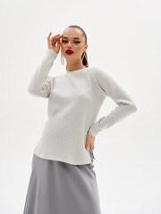 Pregnant girl model in stylish clothes on a colorless background in the studio.