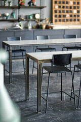industrial art studio with metal chairs and tables against shelves of art supplies. creative workspace environment ideal for artists seeking inspiration and collaboration opportunities