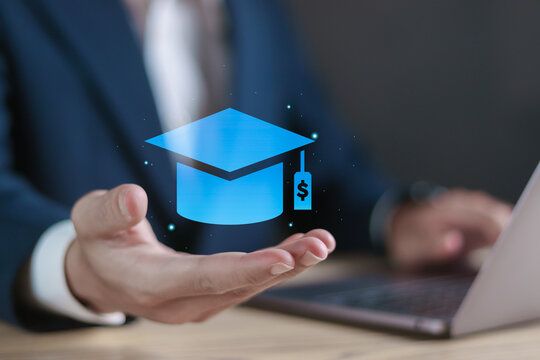 Graduate student loan concept. Government loans, Education financial assistance. Businessman using laptop with graduation cap icon on virtual screen.