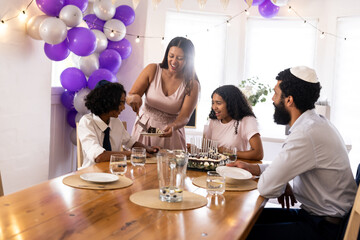 Family celebrating religious occasion at home, sharing cake and smiling together