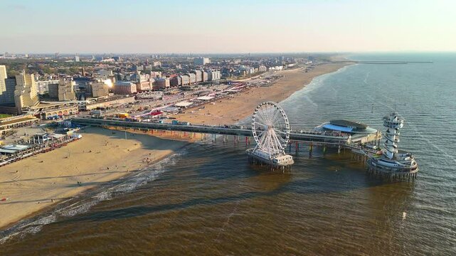 Sunset on the beach in The Hague, Netherlands. The North Sea coast, Scheveningen Pier and the famous Ferris wheel SkyView de Pier.