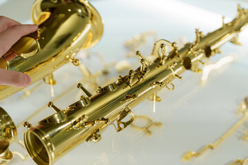 Hand interacts with a golden saxophone display in a music store