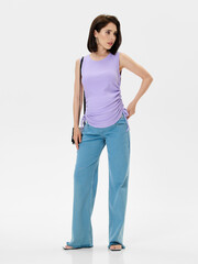 Pregnant girl model in stylish clothes on white background in studio.